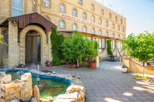 a hotel with a fountain in front of a building at Zamok Hotel in Volgograd