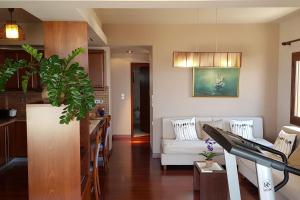 a living room with a white couch and a kitchen at Double View Apartment in Agia Marina Nea Kydonias