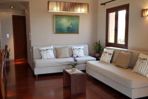 a living room with two white couches and a table at Double View Apartment in Agia Marina Nea Kydonias