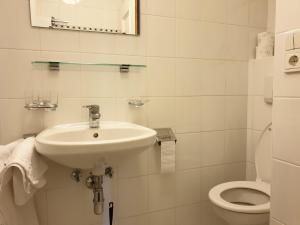 a white bathroom with a sink and a toilet at Haus Schiefer in Leutasch