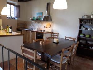 cocina con mesa y sillas en una habitación en Agriturismo Fattoio alle Ripe - Frantoio, en SantʼEllero