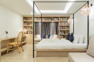 a bedroom with a bed and bookshelves at Amaka Bed and Breakfast in Chiang Mai