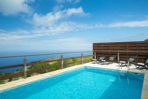 a swimming pool with a view of the ocean at Amadryades Villas in Chortáta