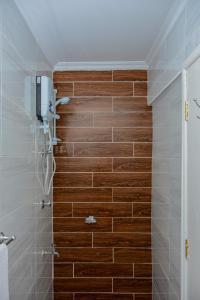 a bathroom with a shower with a wooden wall at Appleton Resort in Nairobi