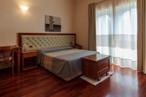 1 dormitorio con cama, mesa y ventana en Hotel Del Corso, en SantʼAntìoco