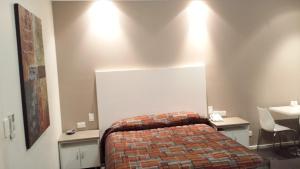 a bedroom with a bed and a desk and a table at McLaren Vale Motel & Apartments in McLaren Vale