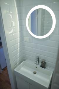 W białej łazience znajduje się umywalka i lustro. w obiekcie MAGIC GARDEN ZAGREB CENTER w Zagrzebiu