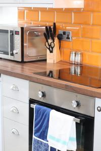 a kitchen counter with a stove and a microwave at Halifax House, Studio Apartment 213 in Halifax