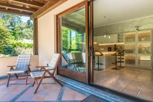 a patio with chairs and a kitchen with sliding glass doors at Villa La Perla - Bellagio in Bellagio