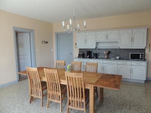 a kitchen with a wooden dining room table and chairs at La Bastide d'Amalthée in Vernay