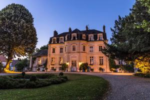 a large house with a driveway in front of it at Najeti Hôtel Château Cléry in Hesdin-lʼAbbé