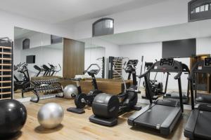 a gym with several treadmills and exercise equipment at TÓTEM Madrid, a Small Luxury Hotel of the World in Madrid