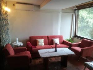 - un salon avec un canapé rouge et une table dans l'établissement Apartments Darinka, à Opatija