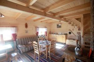 een woonkamer met een tafel en een bank in een hut bij Domek na uboczu in Klikuszowa