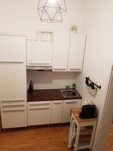 a kitchen with white cabinets and a wooden table at Sweet flat in the center of vienna in Vienna