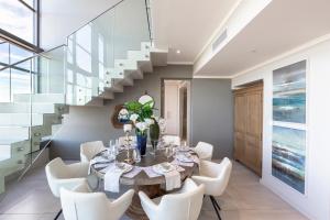uma sala de jantar com uma mesa e cadeiras brancas em Masingita Towers Penthouse em Joanesburgo