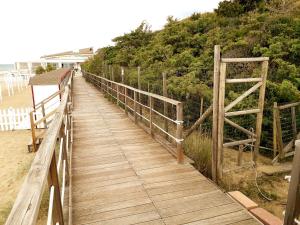 a wooden boardwalk leading down to the beach at Villa Biagi in San Vincenzo