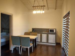 a kitchen with a table and chairs and a microwave at Gradina Forest Villas in Sozopol