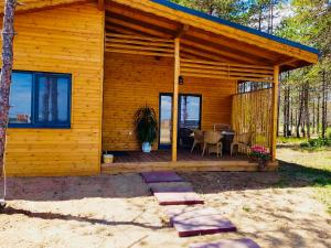 a wooden cabin with a table on a deck at Gradina Forest Villas in Sozopol