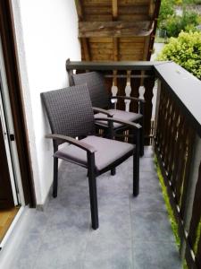 dwa krzesła siedzące na balkonie domu w obiekcie Ferienhaus Waldschmidt w mieście Momlingen