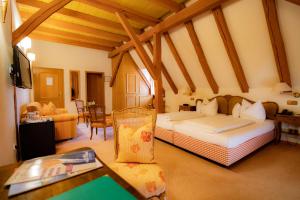 um quarto com 2 camas e uma sala de estar com uma mesa em Landhotel der Schafhof Amorbach em Amorbach