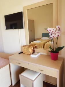 a bedroom with a bed and a desk with a mirror at Hotel Kalamitsi Apartments in Preveza
