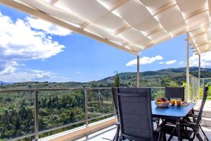 a balcony with a table and chairs and a view of the mountains at Villa Alba in Apolpaina