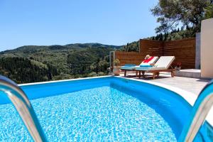 a swimming pool with a woman sitting on a chair next to a table at Villa Alba in Apolpaina