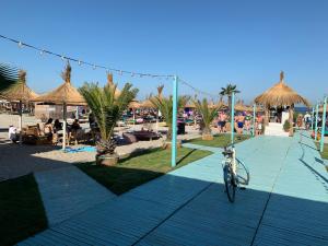 a bike parked on a sidewalk next to a beach at Milan in Mamaia Nord