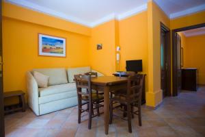 a living room with a couch and a table and chairs at Residence Baia Infreschi in Marina di Camerota