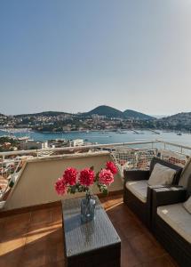 - un balcon avec une table et des fleurs dans l'établissement Adriatic Sea View Apartment, à Dubrovnik