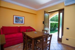a living room with a red couch and a table at Residence Baia Infreschi in Marina di Camerota
