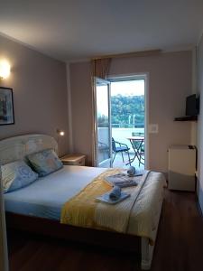 a bedroom with a bed with a view of a balcony at Apartmani Jovanovic in Petrovac na Moru +63 photos