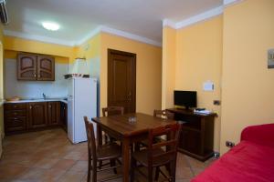 a kitchen and dining room with a table and a refrigerator at Residence Baia Infreschi in Marina di Camerota