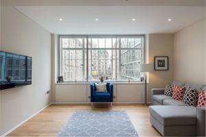 uma sala de estar com um sofá e uma grande janela em Urban Chic - Exeter em Londres