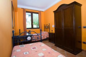 a bedroom with a bed and a cabinet and a window at Residence Baia Infreschi in Marina di Camerota