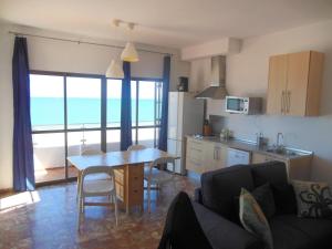 a living room with a table and a kitchen with a view at A la Orilla del Mar in Matalascañas