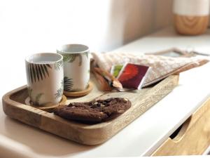 a tray with cookies and two cups on a counter at Casa Caimari Guest House, for mountain lovers! in Caimari