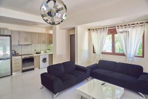 uma sala de estar com dois sofás azuis e uma cozinha em Pura Vida em Rodakino