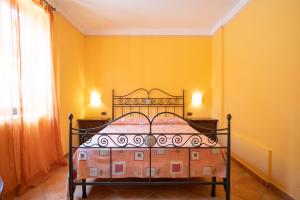 a bedroom with a bed in a yellow wall at Residence Baia Infreschi in Marina di Camerota