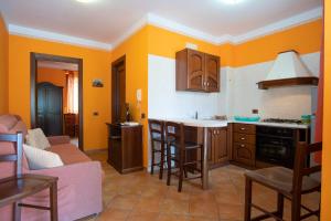 a kitchen with orange walls and a pink couch at Residence Baia Infreschi in Marina di Camerota