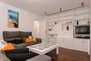 a living room with a couch and a tv at The Circular Villa - jacuzzi, hiking & vineyards in La Matanza de Acentejo