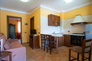 a kitchen with yellow walls and a kitchen with a table at Residence Baia Infreschi in Marina di Camerota