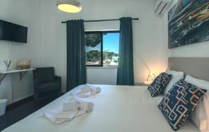 A bed or beds in a room at Pine House - Faro Airport, Beach and City Center