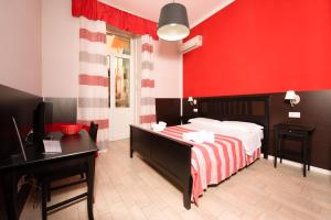 a bedroom with a bed and a red wall at Napoli Experience in Naples