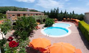 a swimming pool with orange umbrellas and a building at Residence Baia Infreschi in Marina di Camerota