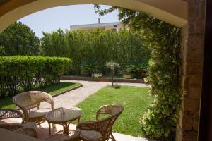 an archway with tables and chairs in a garden at Residence Baia Infreschi in Marina di Camerota