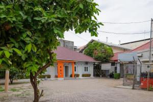 uma casa com uma porta laranja numa rua em RedDoorz Syariah @ Panglima Polem Aceh em Banda Aceh