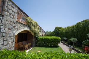 a stone house with a patio and a yard at Residence Baia Infreschi in Marina di Camerota