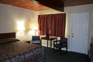 een hotelkamer met een bed, een tafel en stoelen bij Paramount Motel Pocono in East Stroudsburg
